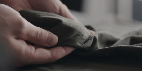 Quality control expert inspecting a garment for excellence, with a checklist and magnifying glass.