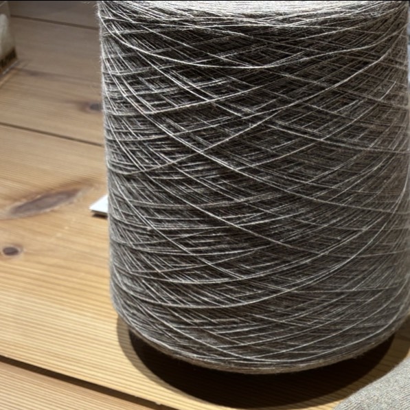 Premium recycled Hanmo yarn cone alongside a finished knit garment at Tani Seni, a leading high-end clothing factory in Tokyo, Japan.